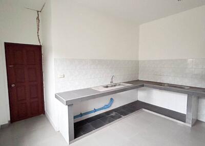 Simple kitchen with tiled countertops and under-sink piping