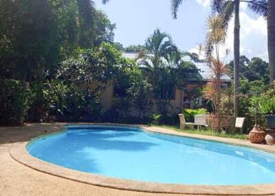 Outdoor pool area with greenery and seating