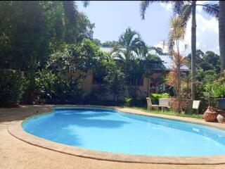 Outdoor pool area with greenery and seating