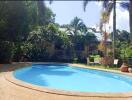 Outdoor pool area with greenery and seating