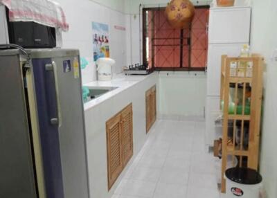 A narrow kitchen with modern appliances and storage options