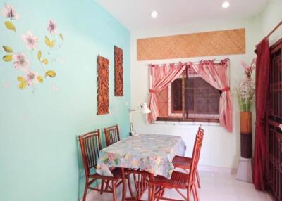 Dining area with a floral-themed wall and natural light