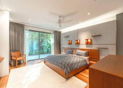 Modern bedroom with large glass doors opening to a garden