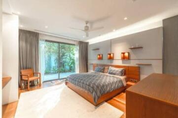 Modern bedroom with large glass doors opening to a garden