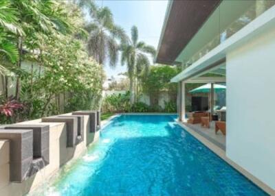 Swimming pool area with outdoor seating and greenery