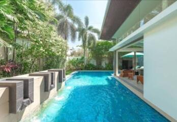 Swimming pool area with outdoor seating and greenery