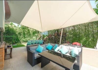Spacious outdoor patio with cozy seating and sunshade