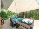 Spacious outdoor patio with cozy seating and sunshade