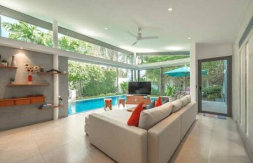 Modern living room with large windows and view of a swimming pool