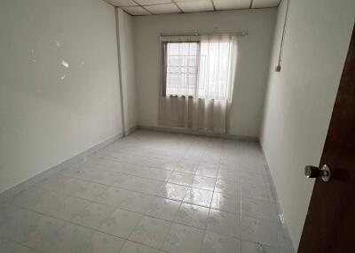 Empty bedroom with window and tiled floor