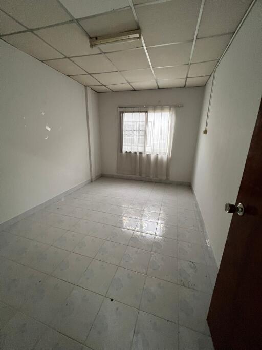 Empty bedroom with window and tiled floor