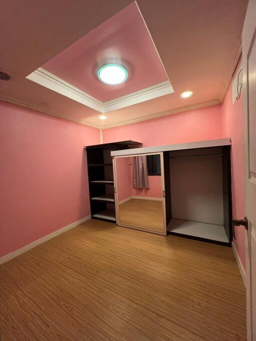 Bedroom with pink walls and built-in closet