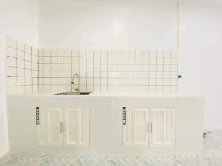 Modern white kitchen with tiled backsplash and sink