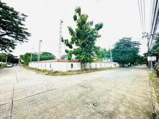 Gated complex with green trees and paved road