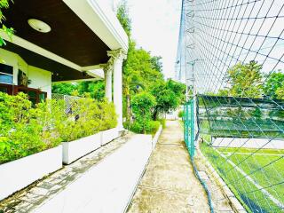 Exterior view of building with garden and sports area