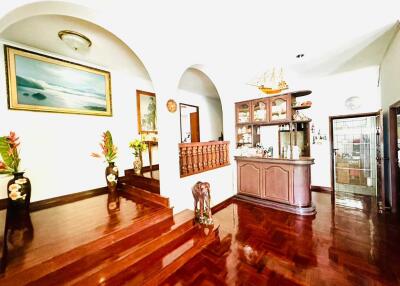 Spacious living room with wooden floors, arched entries, and decorative elements