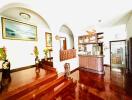 Spacious living room with wooden floors, arched entries, and decorative elements