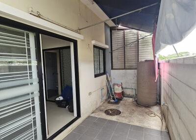 Covered outdoor space with tiled flooring and water tank