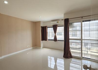 Spacious, well-lit living room with large windows and balcony access