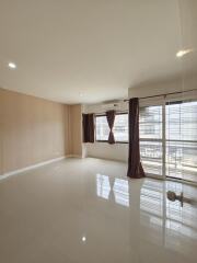 Spacious, well-lit living room with large windows and balcony access