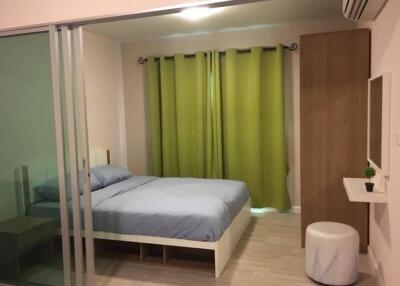 Modern bedroom with glass sliding doors and green curtains