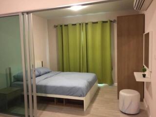 Modern bedroom with glass sliding doors and green curtains