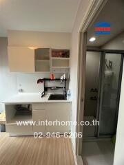 Compact kitchen area with modern cabinets and a view into the adjacent bathroom