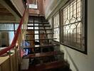 Indoor staircase with metal railings and large window