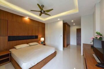 Modern bedroom with wooden accents and ceiling fan