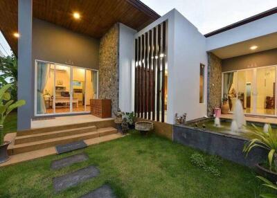 Modern single-story house exterior with garden and water feature