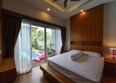 Spacious bedroom with a view of a private pool through sliding glass doors