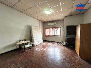 Bedroom with mattress against wall, window with curtains, air conditioner, wardrobe, and tiled floor