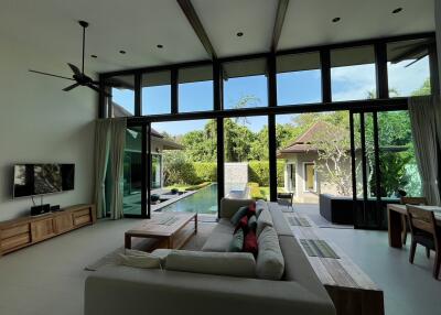 Spacious living room with high ceiling and pool view