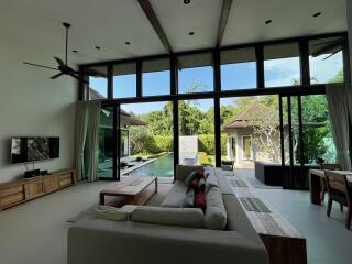 Spacious living room with high ceiling and pool view