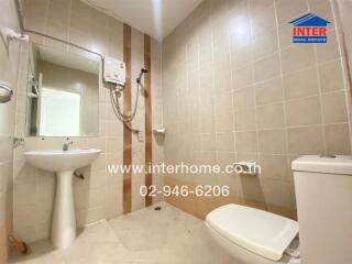Bathroom with mirror, sink, toilet, and water heater