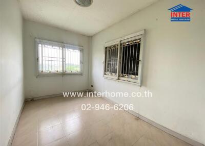 Empty room with tiled floor and barred windows