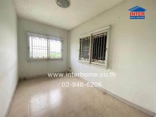 Empty room with tiled floor and barred windows