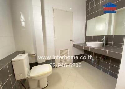 Modern bathroom with toilet, sink, and mirror