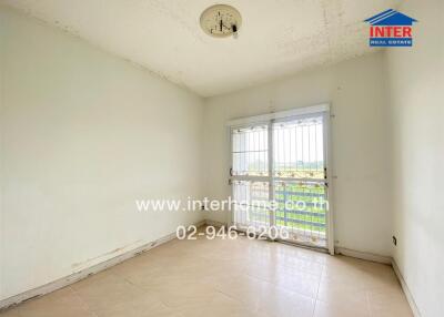 Empty bedroom with large window and tiled floor