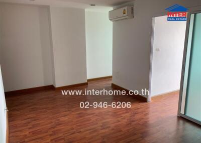 Living room with wooden flooring and wall-mounted AC unit