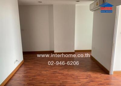 Empty living room with wooden flooring and white walls
