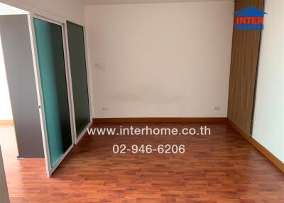 Empty bedroom with wooden floor and sliding glass door