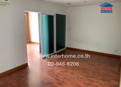 Unfurnished living room with wooden floor, air conditioner, and sliding glass doors.