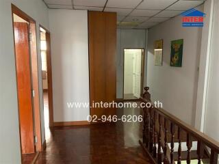 Upper floor hallway with wooden flooring and a wooden railing