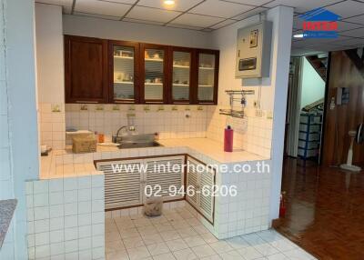 Compact kitchen with tiled counter and wooden cabinets