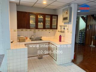 Compact kitchen with tiled counter and wooden cabinets