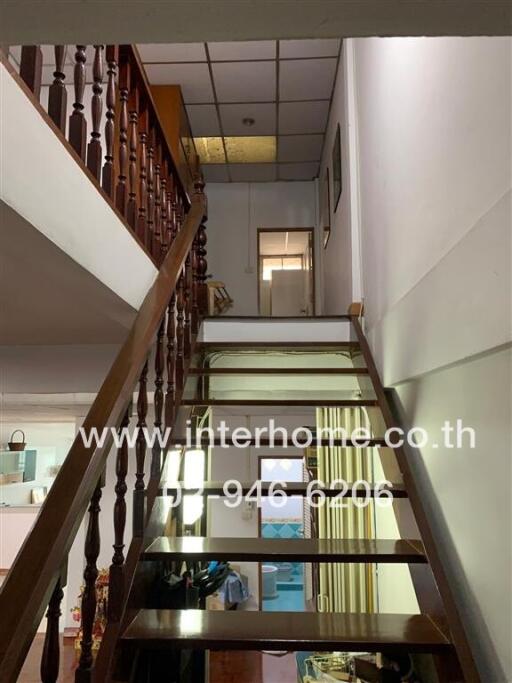 Staircase with wooden handrails leading to the upper floor