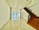 Spacious living room with wooden staircase and ample natural light