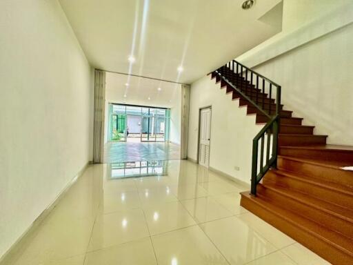 Spacious living room with wooden staircase and ample natural light