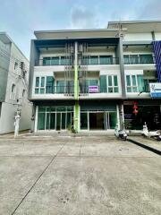 Three-story commercial building with glass storefront and balconies